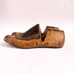 A good pair of antique late nineteenth century polished wooden shoe lasts with leather uppers and steel soles.
