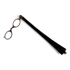 An Edwardian faux tortoiseshell lorgnette - an elegant  pair of fine oval spectacles attached to a long arm in  mock tortoiseshell.