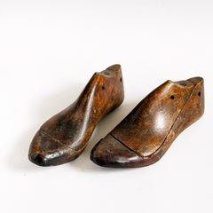 A pair of mid nineteenth century polished wooden shoe lasts with leather toe-capped sides and excellent historical patina.