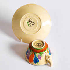 Clarice Cliff early Autumn Crocus Athens cup and saucer with vivid paintwork and boldly executed crocuses, and with early hand painted green "Crocus" stamp on the underside along with "Hand painted Bizarre by Clarice Cliff, Newport Pottery England". 