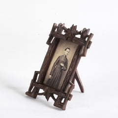A finely carved late nineteenth century Black Forest tabletop photo frame with a hinged back, the frame of entwined rustic branches with vine leaf decoration. 