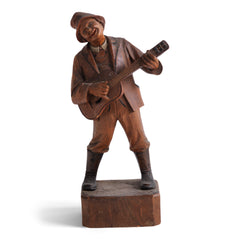 An early twentieth century carved wooden figure of a jovial musician playing a guitar, most likely from Bavaria or the Black Forest, Germany. 