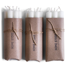 Bundle of church candles containing beeswax wrapped in brown paper and  tied with string.