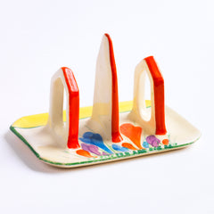 Original 1920s Clarice Cliff Autumn Crocus toast rack for two with good, bright and bold paintwork. The underside is stamped "Hand painted Bizarre by Clarice Cliff Wilkinson Ltd England".