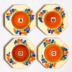 Clarice Cliff early Autumn Crocus octagonal tea plates with vivid paintwork and boldly executed crocuses, and with early hand painted green "Crocus" stamp on the reverse. The underside to each is also stamped "Hand painted Bizarre by Clarice Cliff, Newport Pottery England". 