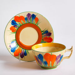 Clarice Cliff early Autumn Crocus Athens cup and saucer with vivid paintwork and boldly executed crocuses, and with early hand painted green "Crocus" stamp on the underside along with "Hand painted Bizarre by Clarice Cliff, Newport Pottery England". 