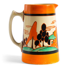 An original 1929 Clarice Cliff Orange Trees & House pattern Athens shape jug with brilliant, bright paintwork. The underside is stamped Fantasque Hand Painted Bizarre by Clarice Cliff Newport Pottery England. 