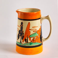 An original 1929 Clarice Cliff Orange Trees & House pattern Athens shape jug with brilliant, bright paintwork. The underside is stamped Fantasque Hand Painted Bizarre by Clarice Cliff Newport Pottery England. 