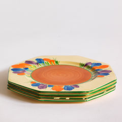 Clarice Cliff early Autumn Crocus octagonal tea plates with vivid paintwork and boldly executed crocuses, and with early hand painted green "Crocus" stamp on the reverse. The underside to each is also stamped "Hand painted Bizarre by Clarice Cliff, Newport Pottery England". 