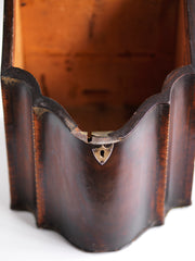 Detail of a George III mahogany veneered knife box with an elegant star inlay on the slope of its lid. The serpentine front is banded in satinwood, and it has a compass star decoration with rope cross-banded inlay applied to the underside of its lid - with a silver shield-shaped escutcheon to the lock on the front. 