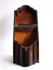 A George III mahogany veneered knife box with an elegant star inlay on the slope of its lid. The serpentine front is banded in satinwood, and it has a compass star decoration with rope cross-banded inlay applied to the underside of its lid - with a silver shield-shaped escutcheon to the lock on the front. 