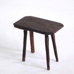 A vintage Romanian folk art small wooden side table with rustic stick legs.