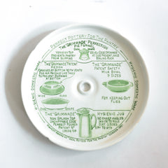 The lid underside of a vintage ironstone Grimwades pudding bowl with central heat funnel and fitted lid. The bowl and lid are liberally decorated with graphic typography and illustrations on how to use the Quick Cooker.