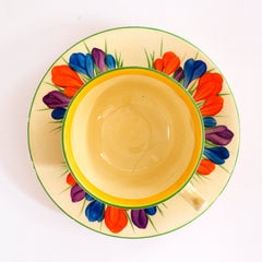 Clarice Cliff early Autumn Crocus Athens cup and saucer with vivid paintwork and boldly executed crocuses, and with early hand painted green "Crocus" stamp on the underside along with "Hand painted Bizarre by Clarice Cliff, Newport Pottery England". 