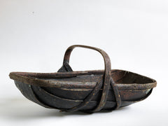 An extra-large rustic antique trug, with a particularly pleasing historic sheet-metal repair to its interior, and a lovely patina formed from decades of use.