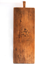 A huge vintage bread board with handle and hanging hole and beautiful polished time worn surface.