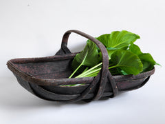 An extra-large rustic antique trug, with a particularly pleasing historic sheet-metal repair to its interior, and a lovely patina formed from decades of use.