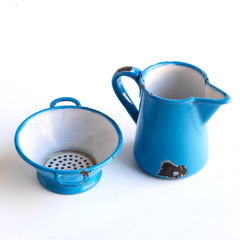 Two very pleasing antique miniature blue enamel kitchen items: a twin-handled sieve and a ewer shaped jug, each with a blue enamel exterior and a white enamel interior. These are part of an extensive collection of miniature pale blue enamel kitchen ware, previously owned by the miniaturist specialist and collector extraordinaire Joan Dunk.