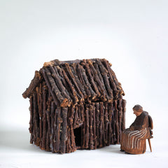 A miniature naive carved wooden figure of a peasant women seated on an Alpine chair, with its original staining and paint - mid century, Bavarian. And a rustic miniature house of twigs.