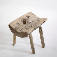 An antique primitive wabi-sabi style wooden stick stool, the top crafted from a single section of trunk.