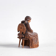 A miniature naive carved wooden figure of a peasant women seated on an Alpine chair, with its original staining and paint - mid century, Bavarian.