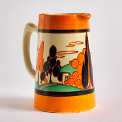 An original 1929 Clarice Cliff Orange Trees & House pattern Athens shape jug with brilliant, bright paintwork. The underside is stamped Fantasque Hand Painted Bizarre by Clarice Cliff Newport Pottery England. 