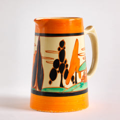 An original 1929 Clarice Cliff Orange Trees & House pattern Athens shape jug with brilliant, bright paintwork. The underside is stamped Fantasque Hand Painted Bizarre by Clarice Cliff Newport Pottery England. 