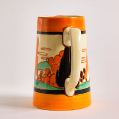 An original 1929 Clarice Cliff Orange Trees & House pattern Athens shape jug with brilliant, bright paintwork. The underside is stamped Fantasque Hand Painted Bizarre by Clarice Cliff Newport Pottery England. 