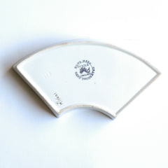 Part of a mid century vintage Poole Pottery seafood hors d'oeuvre set consisting of five ceramic dishes that fit snugly into a circular wooden tray.  This image shows the underside maker's stamp. Each crescent shaped dish is decorated with a hand painted pattern of a shrimp, a flatfish, a crab and a scallop - designed by Truda Carter and hand painted on Poole Pottery's alpine white glaze. Each piece is stamped to its underside "Handmade Hand Decorated Poole England", along with the paintress's mark.