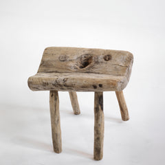 An antique primitive wooden stick stool, the top crafted from a single section of trunk.
