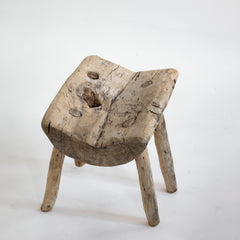 An antique primitive wooden stick stool, the top crafted from a single section of trunk.