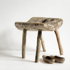 An antique primitive wooden stick stool, the top crafted from a single section of trunk.