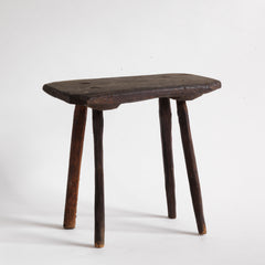 A vintage Romanian folk art small wooden side table with rustic stick legs.