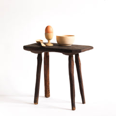 A vintage Romanian folk art small wooden side table with rustic stick legs.