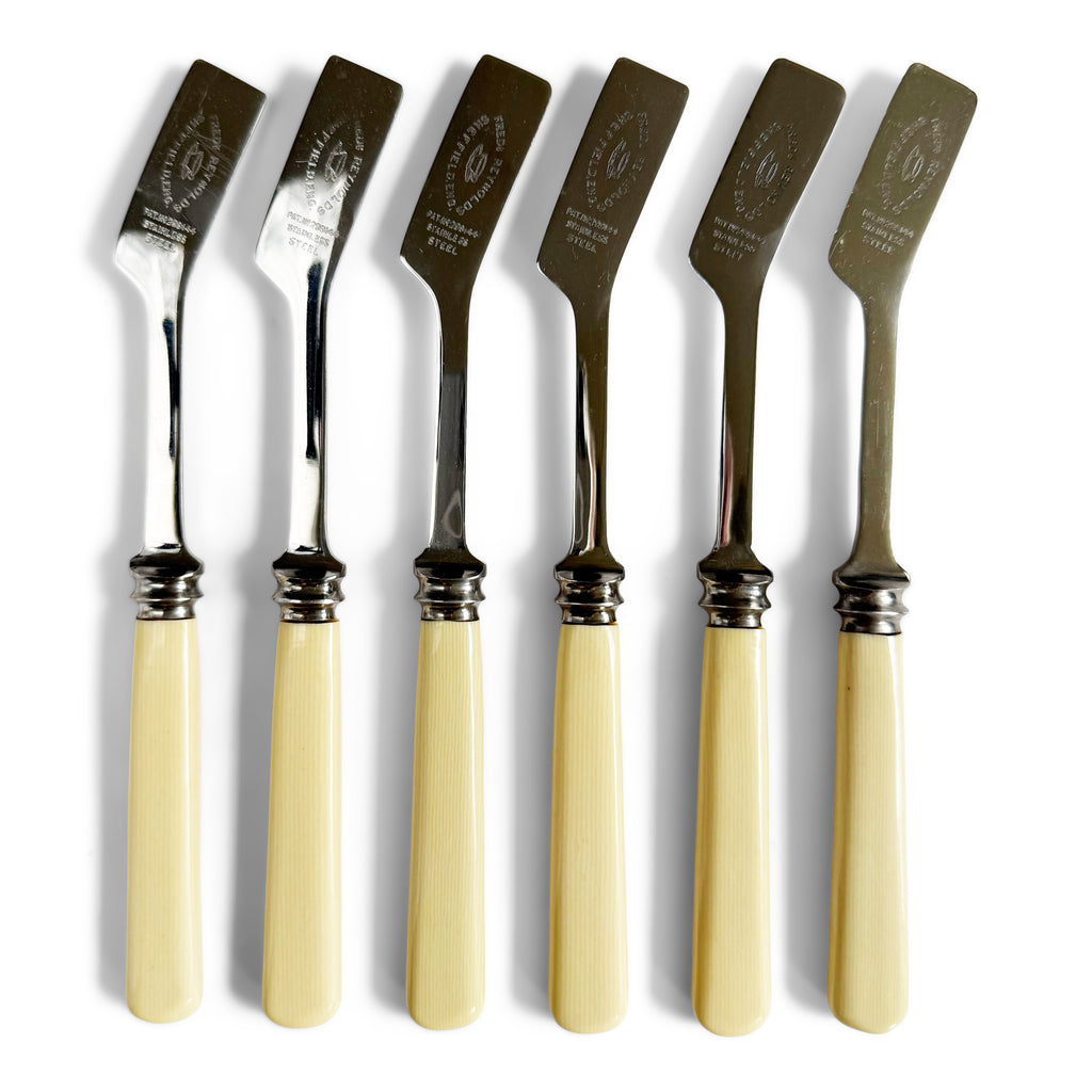 Set of 6 vintage bone handle scone knives each blade marked "Frederick Reynolds" alongside an engraved tea cup and saucer motif. The unusual blade is specially designed for scooping and spreading butter, jam and cream over small areas, such as a scone.