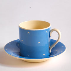 The coffee can  in a complete 1930s Art Deco Susie Cooper Blue Crescent Kestrel coffee set decorated with small scarffito crescents. It includes a coffee pot, milk jug, sugar bowl, and six coffee cans and saucers.