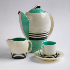 A good 1930s Art Deco Susie Cooper coffee set decorated with green and black banding. Restraint, fitness for purpose and a careful consideration for shape and pattern are Susie Cooper hallmarks, to which this rare 1930s Kestrel shape coffee set in green Tango stands testament. The Susie Cooper trademark 1930s signature leaping deer logo is on the underside of each piece, and the set includes a coffee pot, milk jug, and six coffee cans and saucers.