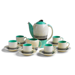 A good 1930s Art Deco Susie Cooper coffee set decorated with green and black banding. Restraint, fitness for purpose and a careful consideration for shape and pattern are Susie Cooper hallmarks, to which this rare 1930s Kestrel shape coffee set in green Tango stands testament. The Susie Cooper trademark 1930s signature leaping deer logo is on the underside of each piece, and the set includes a coffee pot, milk jug, and six coffee cans and saucers.