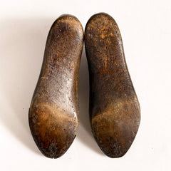 The underside of a pair of mid nineteenth century polished wooden shoe lasts with leather toe-capped sides and excellent historical patina.