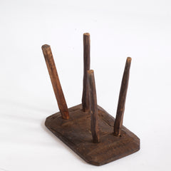 A vintage Romanian folk art small wooden side table with rustic stick legs, showing the underside.