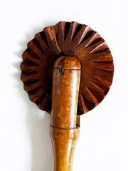 Detail of a Victorian pastry cutting wheel with a polished turned boxwood handle.