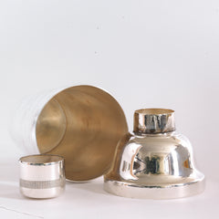 Inside view of a vintage silver plated cocktail shaker of three sections with internal strainer and a cap top.