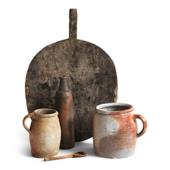 A collection of vintage French rustic earthenware confit pots in greys, beiges and browns, and a sculptural matt moleskin brown ceramic calvados bottle. 