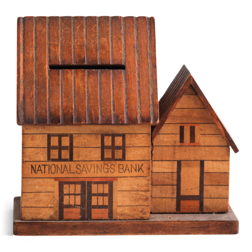 A vintage naive model wooden house piggy bank, the frontage with typography "National Savings Bank".