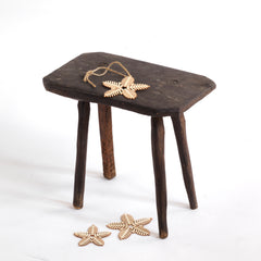 A vintage Romanian folk art small wooden side table with rustic stick legs.