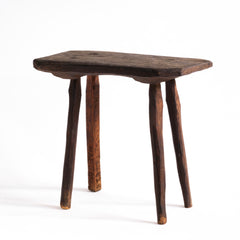 A vintage Romanian folk art small wooden side table with rustic stick legs.