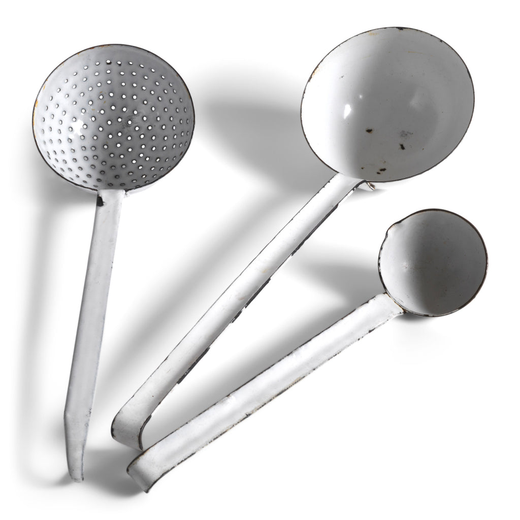 A collection of three vintage enamel kitchen ladles: a scoop with a perforated bowl - perfect for the singling out poached or fried food and draining; a large ladle, and a small sauce ladle with a handy pouring lip - and also ideal for gravy.