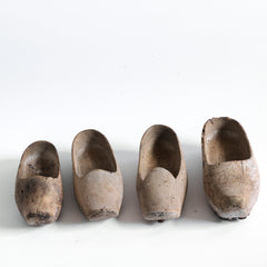A collection of tiny French wooden children's sabot (clogs), some with hob-nails attached underneath. 