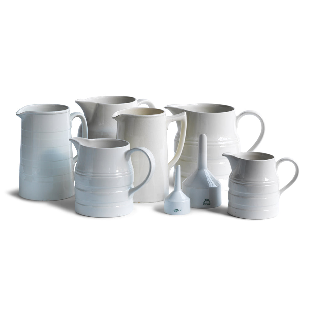 A collection of good late nineteenth century and early twentieth century ironstone and creamware water jugs and funnels