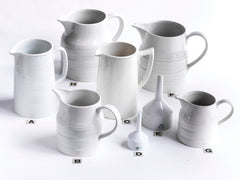 A collection of good late nineteenth century and early twentieth century ironstone and creamware water jugs and funnels